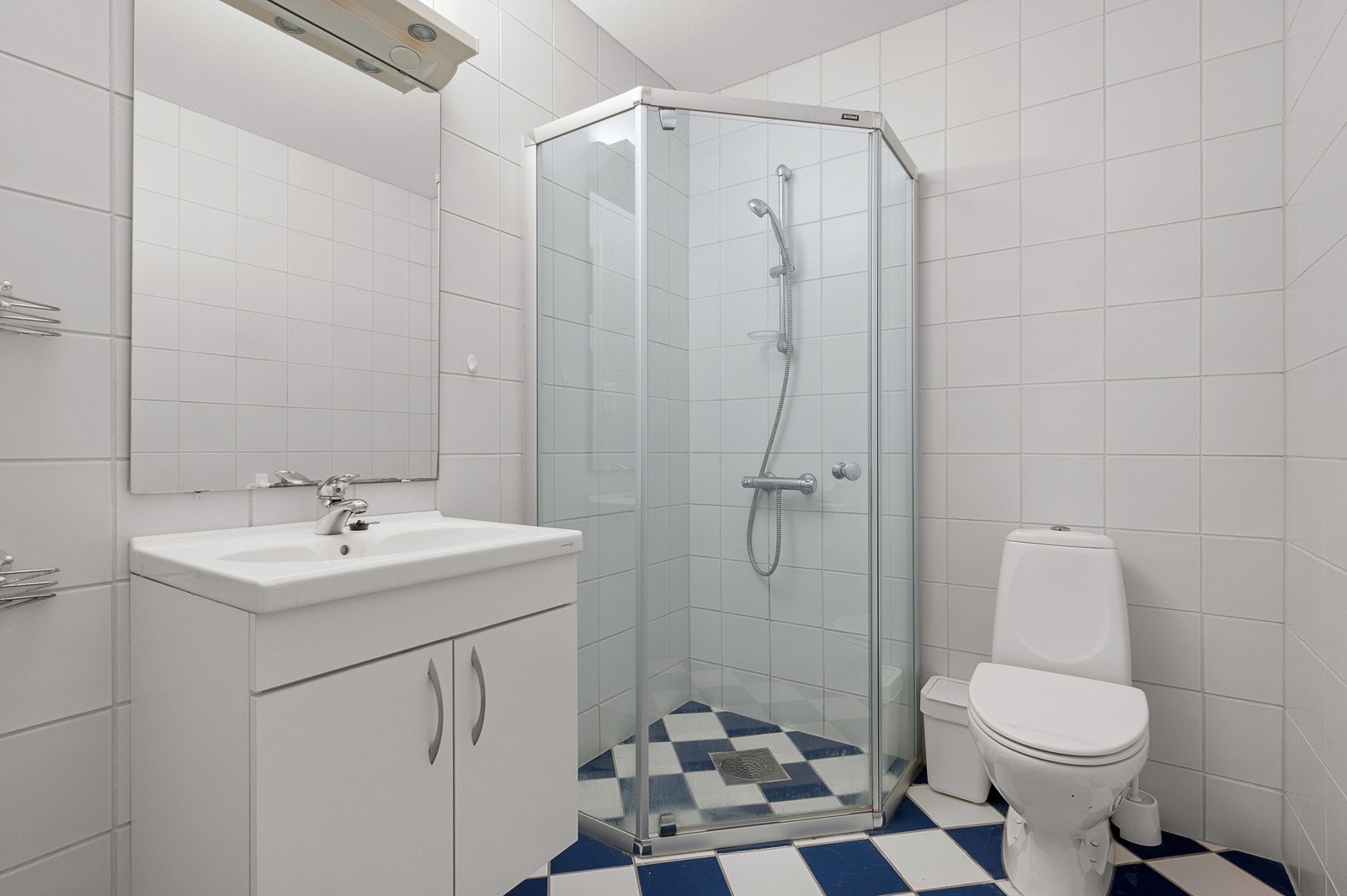 Flislagt bad med dusjnisje, servant og toalett Galleribilde