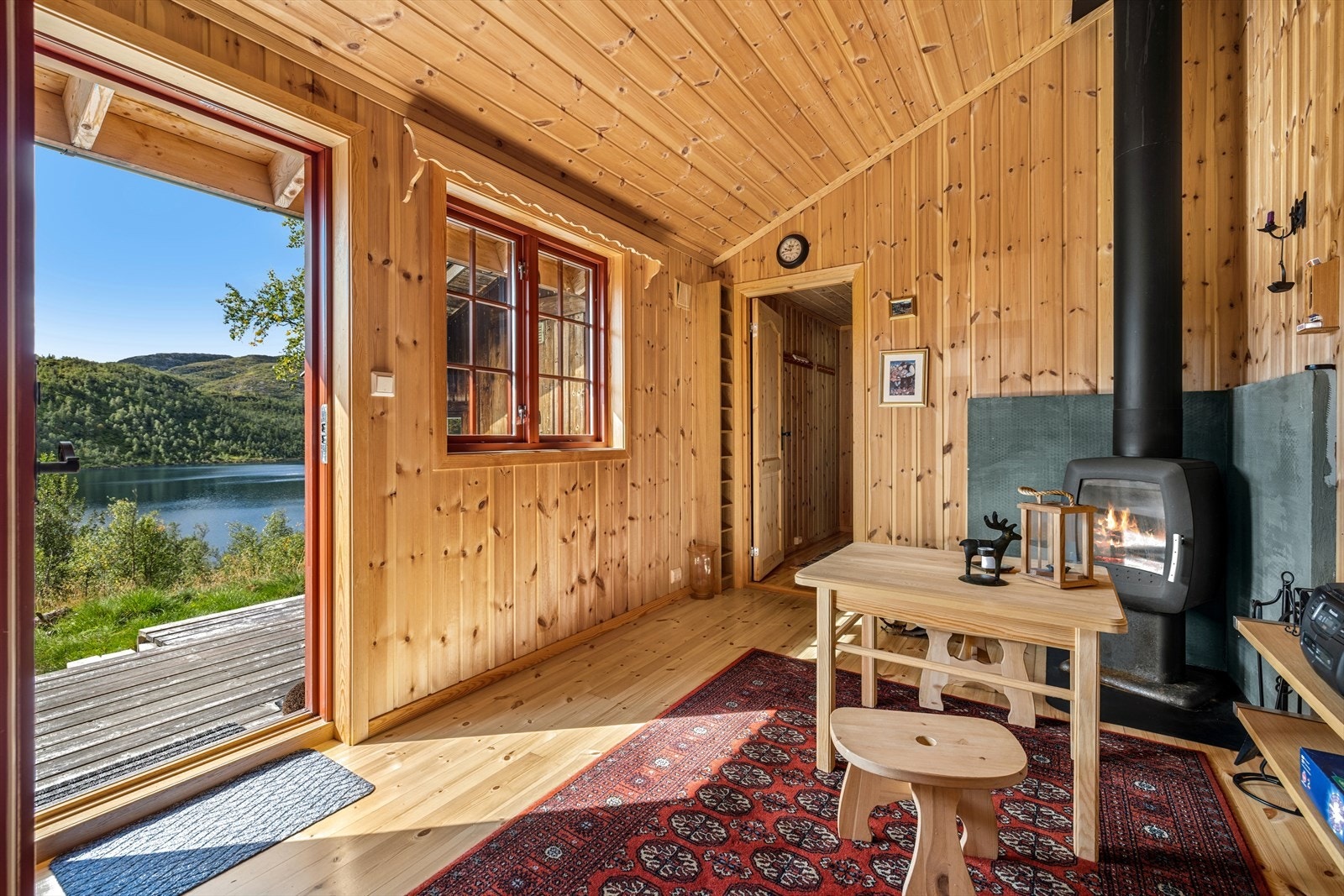I påbygget kommer man rett inn i stuen med vedovn og sitteplasser Galleribilde