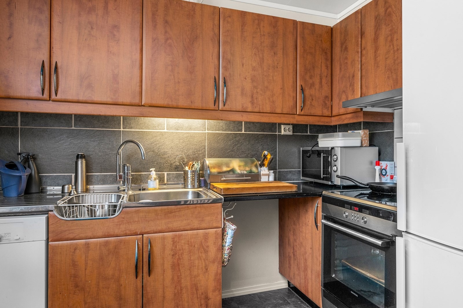 Kjøkkenet har rikelig med skap og benkeplass. Galleribilde