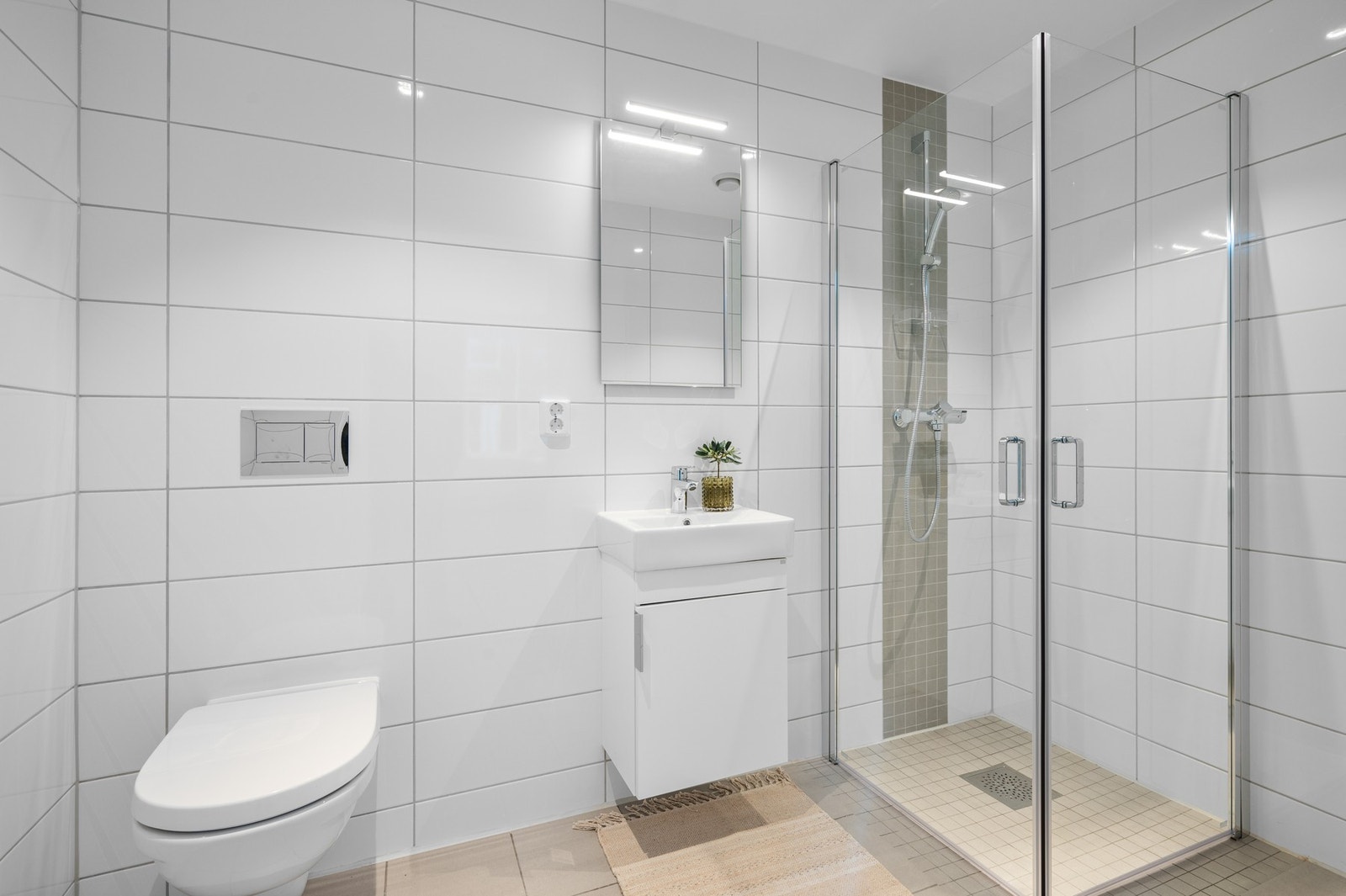 Pent flislagt bad tilhørende hovedsoverommet på ca. 4 kvm. Inneholder vegghengt wc, dusjhjørne og servant med speil. Galleribilde