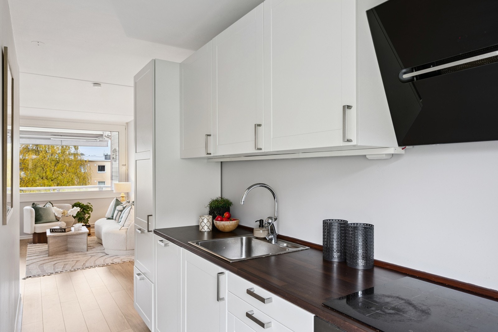 Pent kjøkken med integrerte hvitevarer som stekeovn, koketopp, oppvaskmaskin, samt kjøl- og fryseskap. Galleribilde