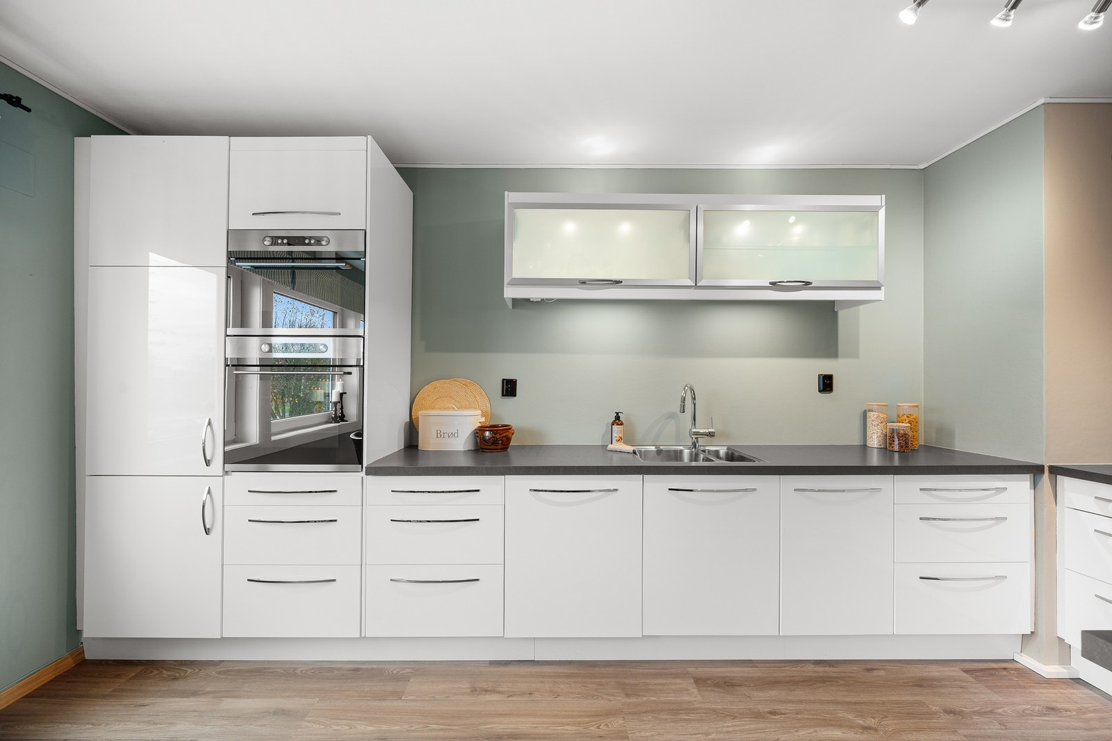 Kjøkkenet har integrerte hvitevarer som gir et helhetlig og stilrent uttrykk. Her finner du platetopp, stekeovn, oppvaskmaskin, mikrobølgeovn og kjøle-/fryseskap. Galleribilde