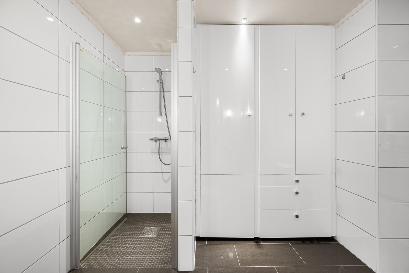 Badet er utstyrt med en stor dusjnisje og gode oppbevaringsmuligheter - praktisk utforming som gir god plass og orden. Galleribilde