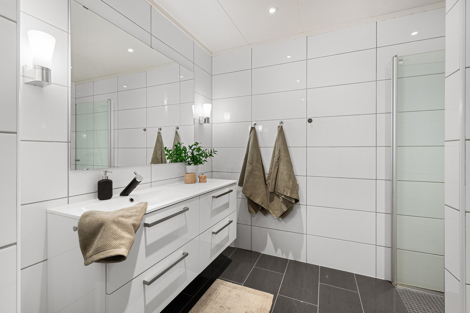 Badet ble er fra 2012 og fremstår pent flislagt med varme i gulv. Takstmann har gitt rommet tilstandsgrad 1, med mindre anmerkninger knyttet til tekniske detaljer som høydeforskjell og sisterne. Galleribilde