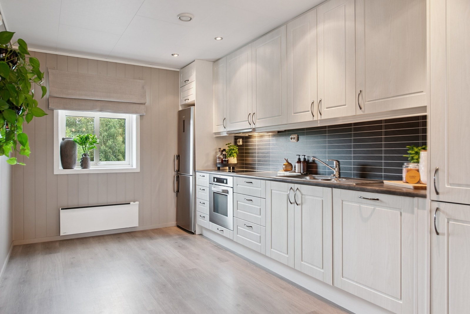 Lyst og funksjonelt kjøkken med innholdsrik innredning. Galleribilde