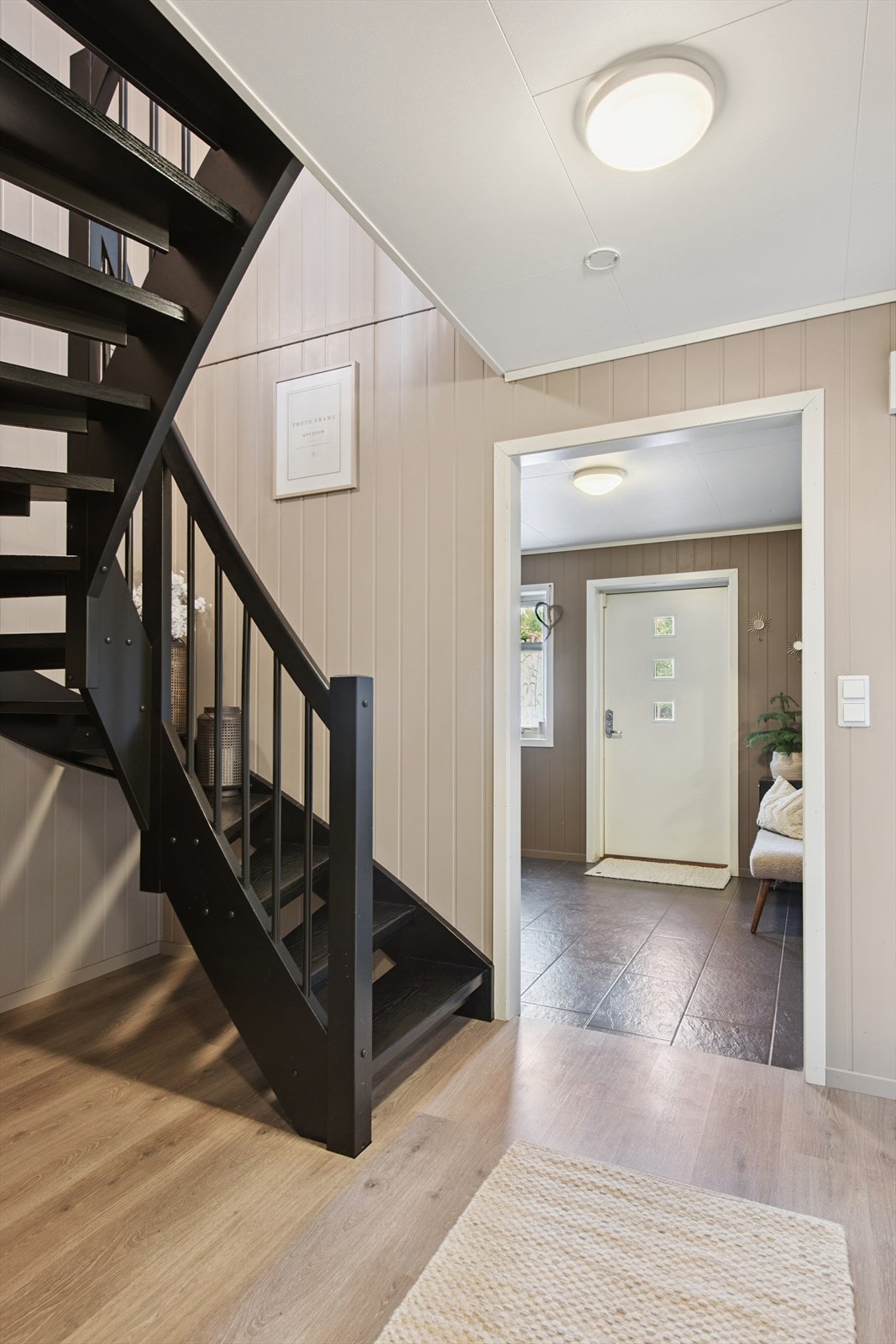 Fra gangen en en stilren tretrapp som binder boligens to plan elegant sammen. Galleribilde