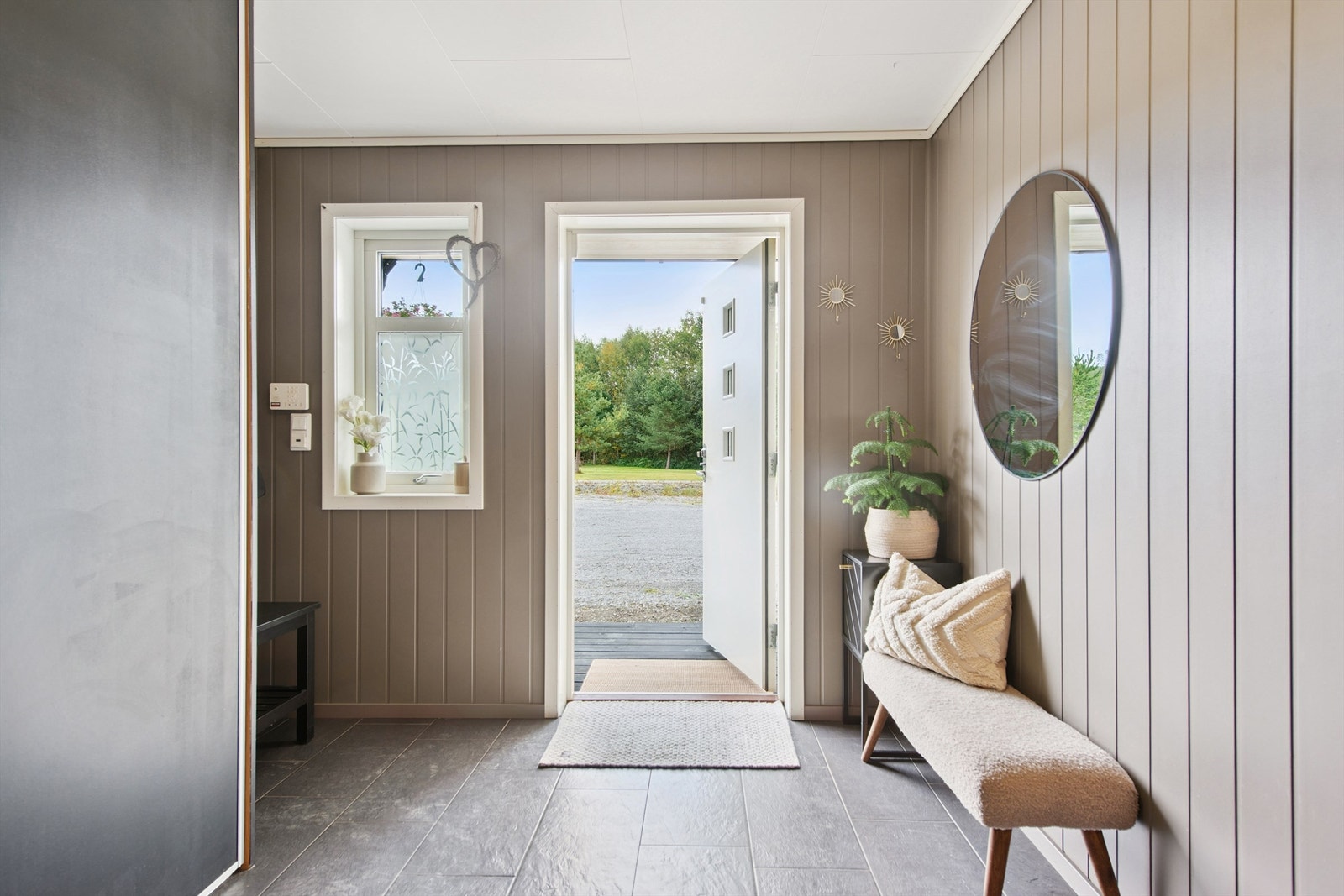 Innbydende entré med flislagt gulv og malte MDF-veggplater. Galleribilde