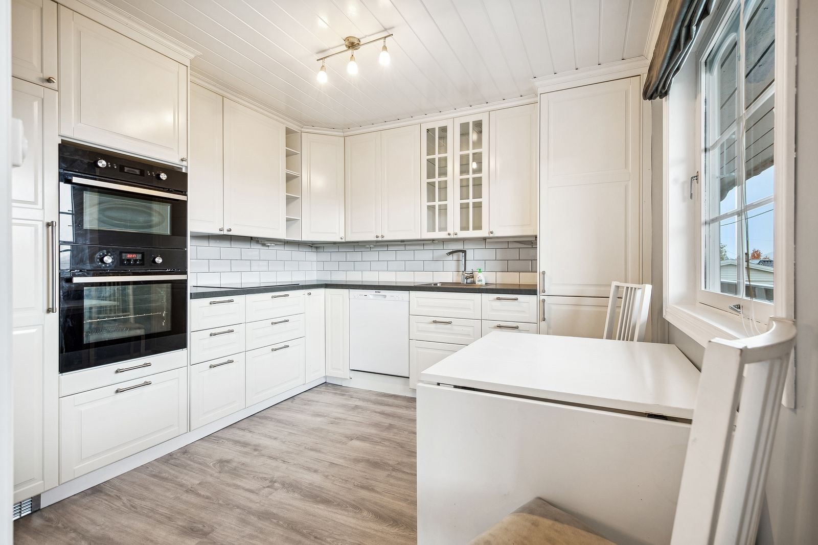 Hvitt stilfullt kjøkken med integrerte hvitevarer. Galleribilde