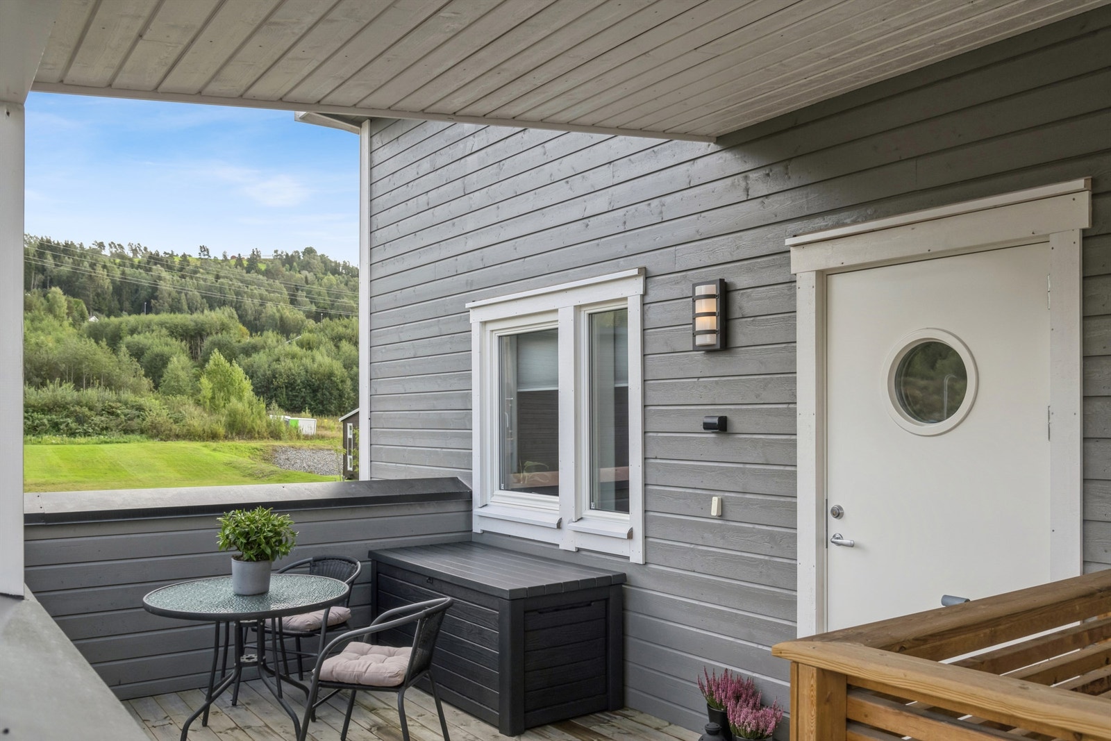 Overbygget inngangsparti med plass til en liten sittegruppe. Galleribilde