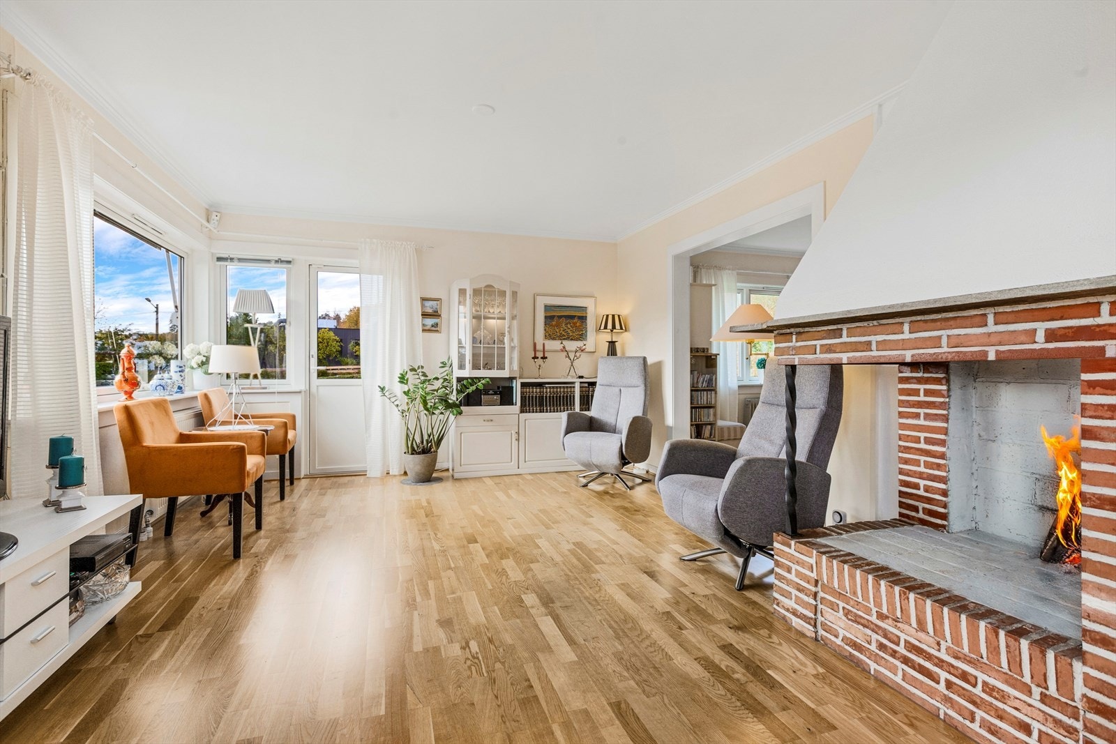 Romslig stue med tregulv, peis og store vindusflater som gir rikelig med naturlig lys. Utgang til solrik veranda Galleribilde