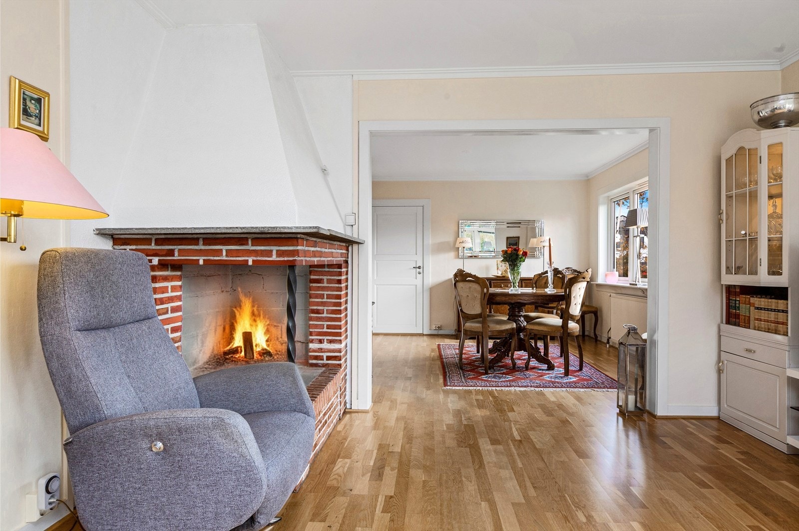 Koselig stue med peis og åpen løsning mot spisestue Galleribilde