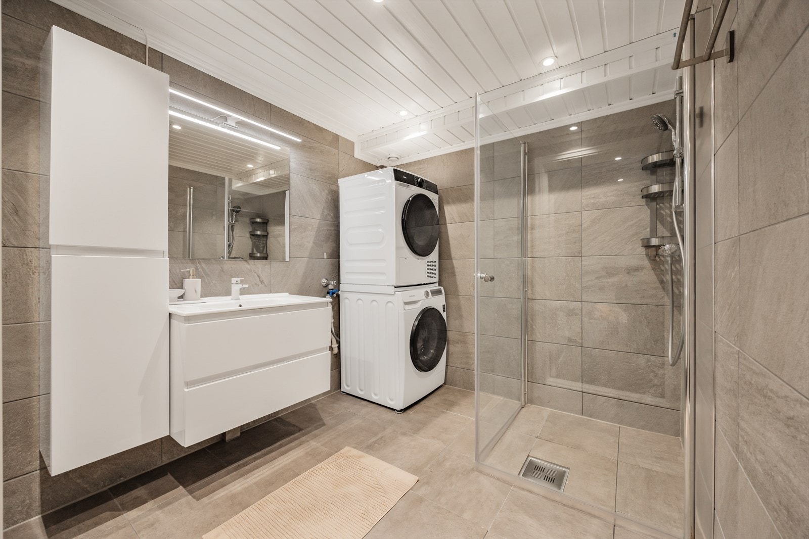 Lekkert flislagt baderom. Romslig, med opplegg for vaskemaskin og tørketrommel. Galleribilde