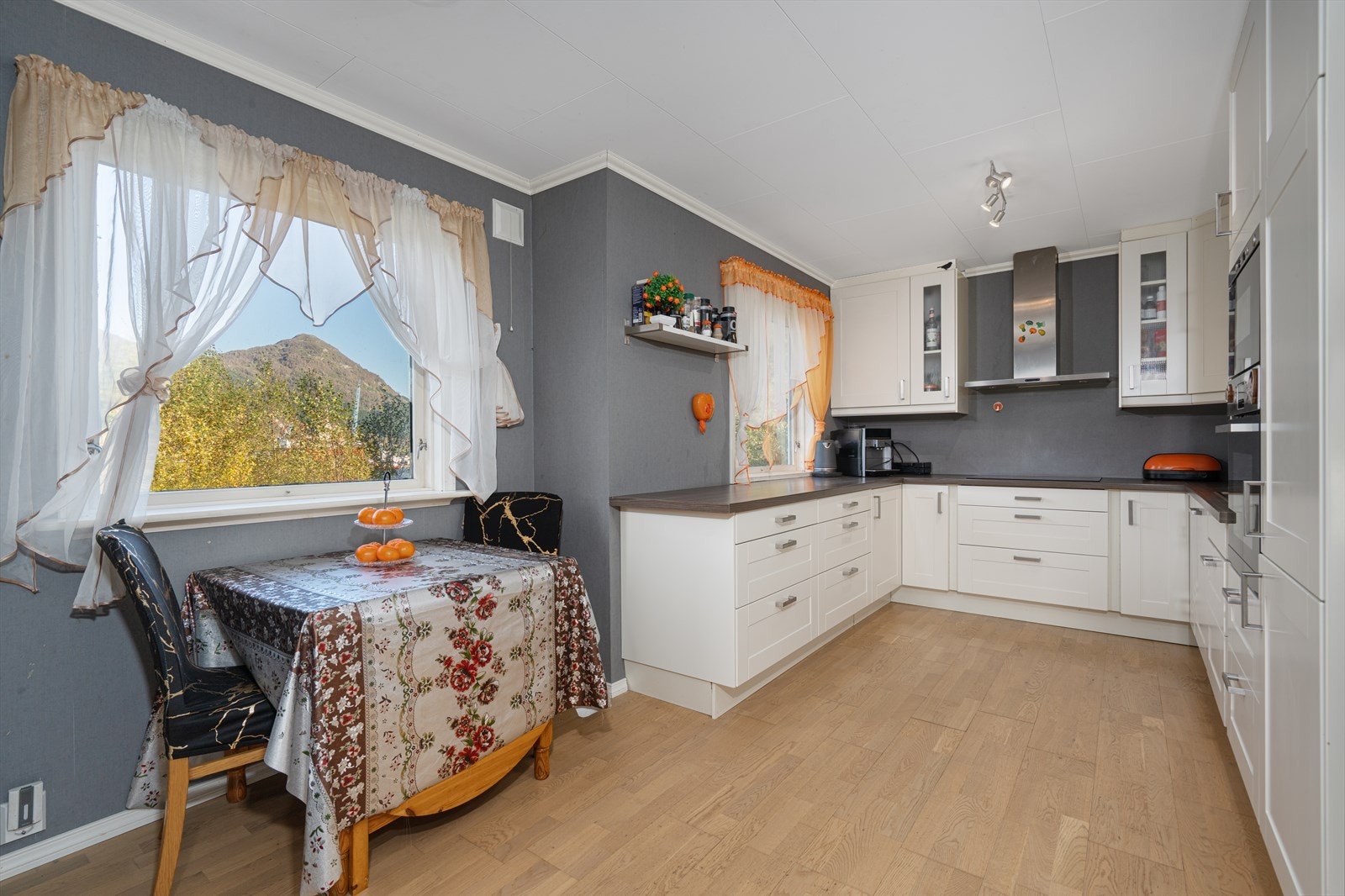 Kjøkken er lyst og tidløst, med integrerte hvitevarer. Kjøkkeninnredning med lyse lakkerte fronter og benkeplate i laminat. Galleribilde