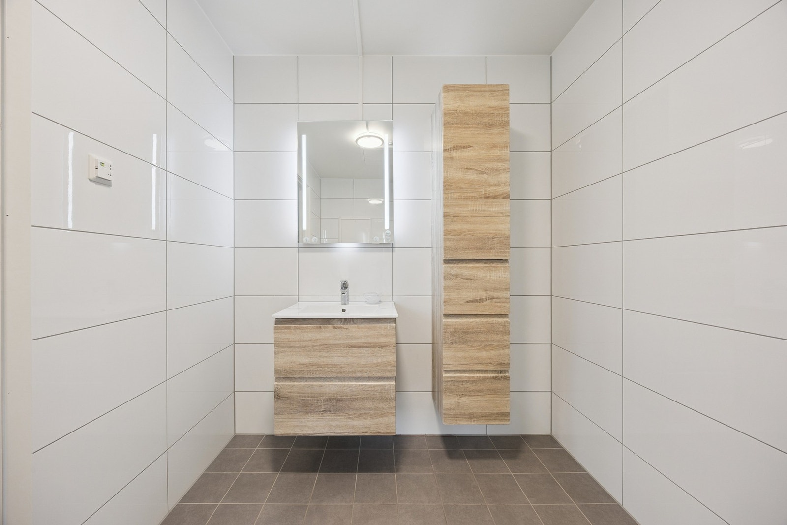 Badet er innredet med nedfelt servant, toalett og dusjhjørne Galleribilde