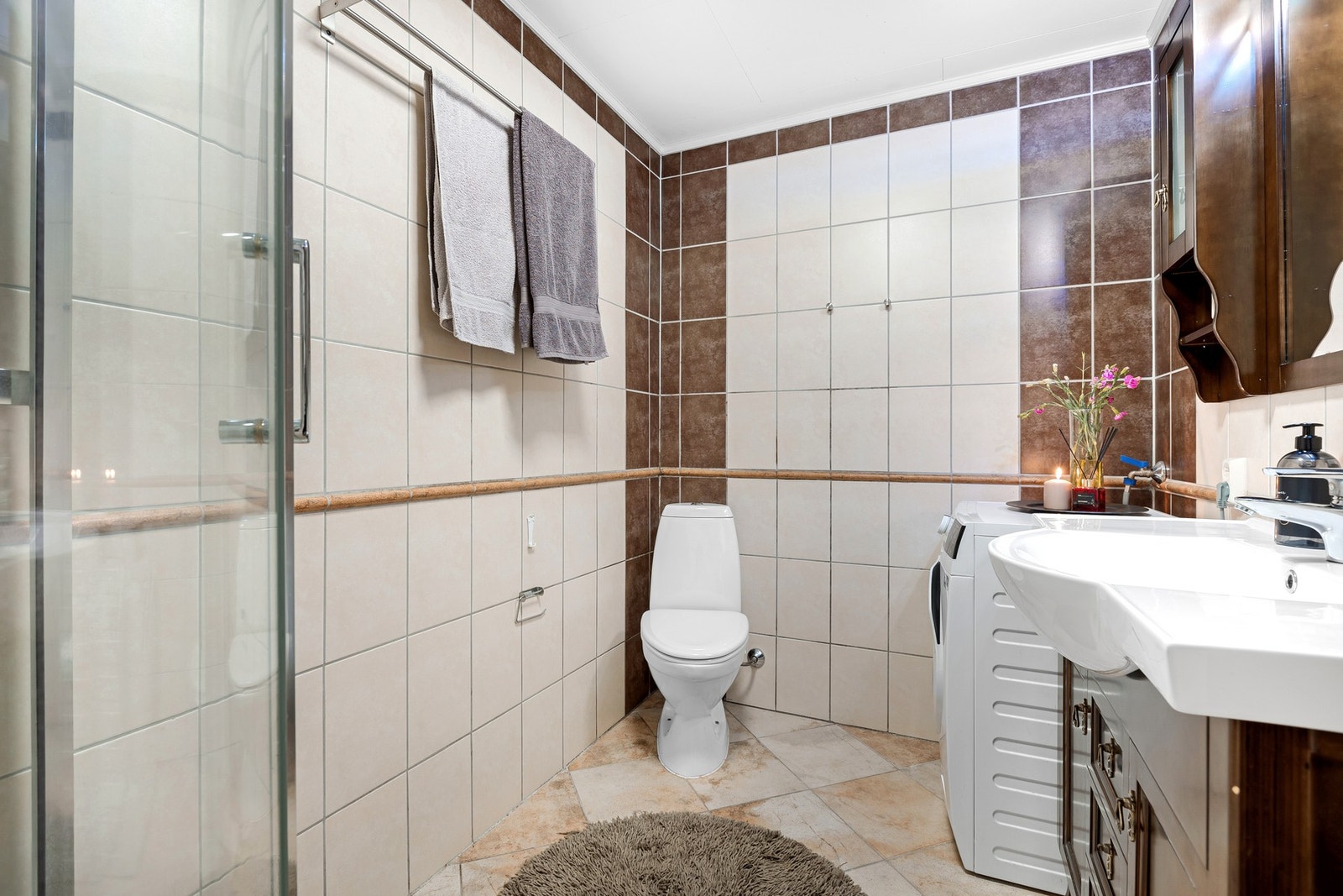 Flislagt bad med opplegg for oppvaskmaskin, innredning med speil og belysning. Galleribilde