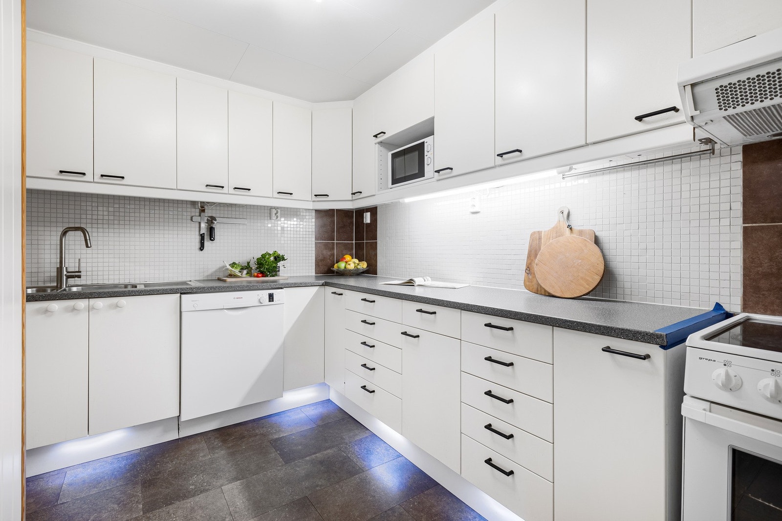 Kjøkken med lyse fronter, godt med skap- og benkeplass. Galleribilde