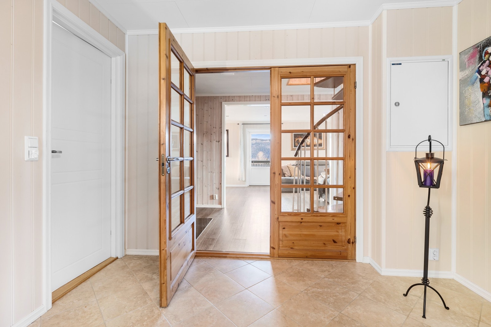 Entre med flislagt gulv og garderobeløsning. Galleribilde