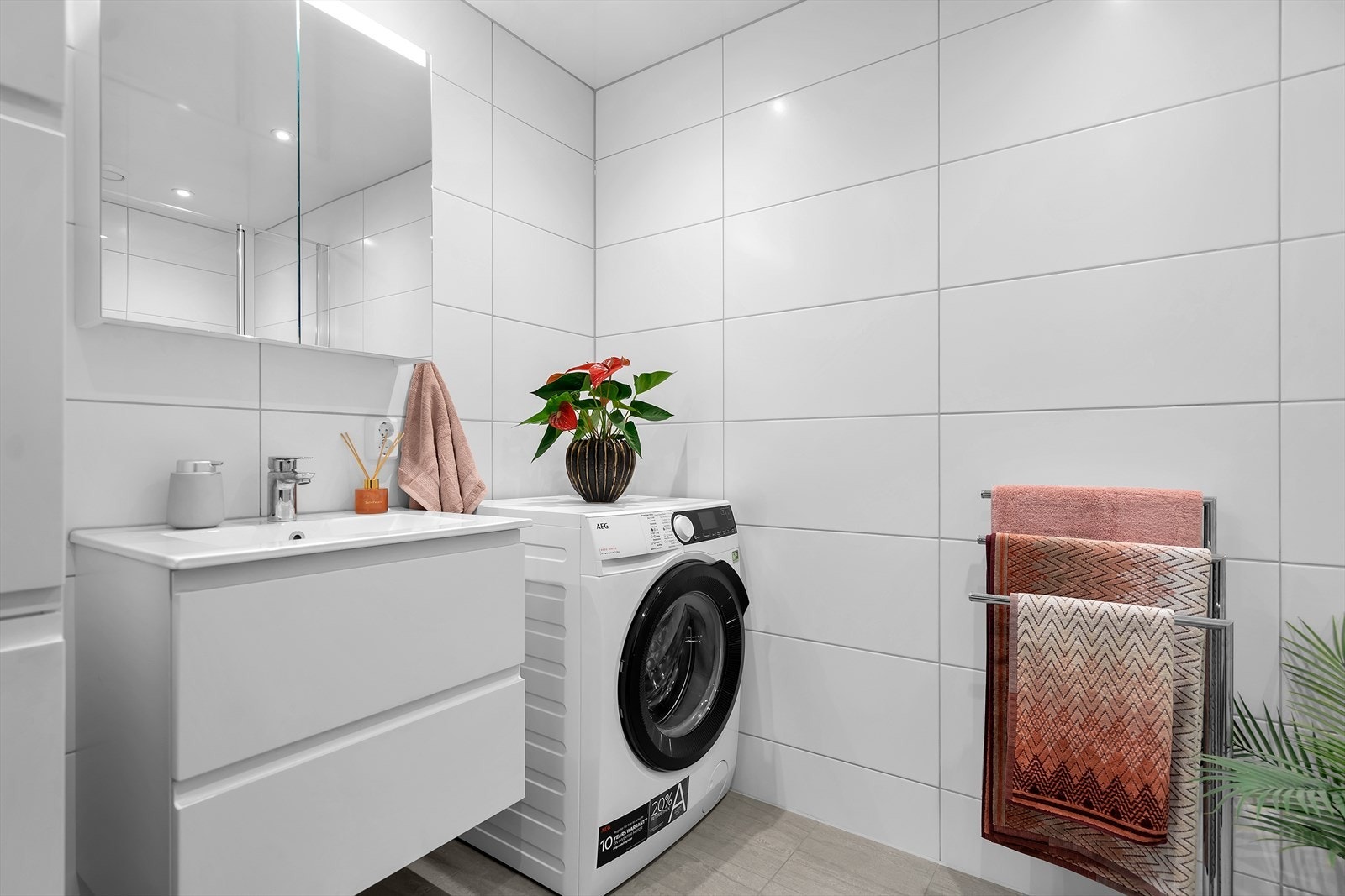 Rommet har en stor og moderne dusjnisje med glassvegger, et praktisk speilskap med integrert belysning, og en servant med romslige underskuffer for oppbevaring. Galleribilde