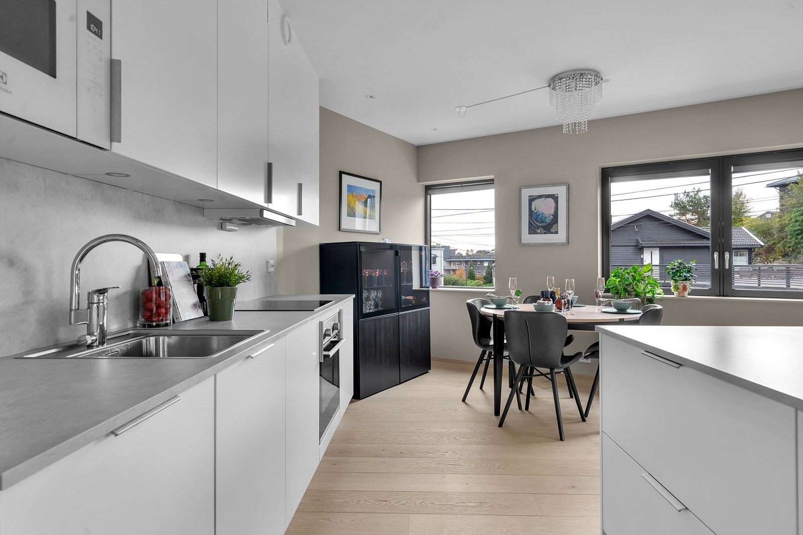 Pene detaljer som integrerte hvitevarer, belysning over kjøkkenbenken og en praktisk kjøkkenøy som gir ekstra arbeidsplass og gjør kjøkkenet til en sosial sone. Galleribilde