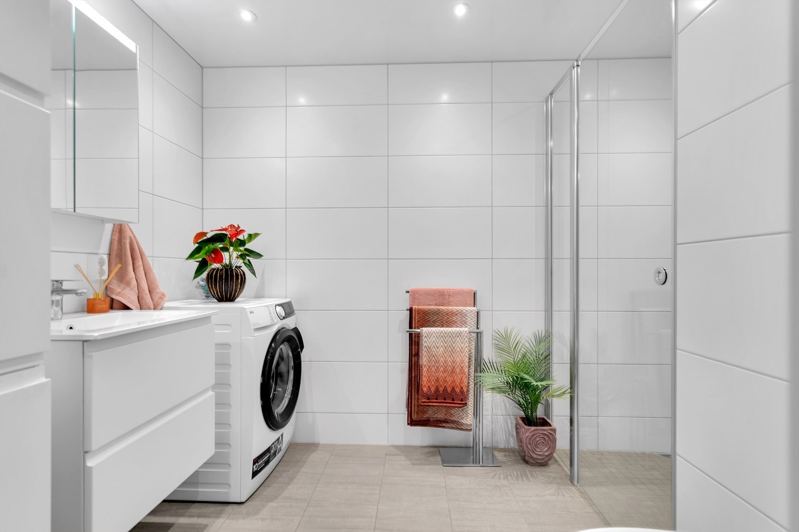 Det elegante, helflislagte baderommet er utformet med øye for både stil og funksjonalitet. Komfort og atmosfære er ivaretatt med downlights i taket, mekanisk avtrekk og vannbåren gulvvarme. Galleribilde