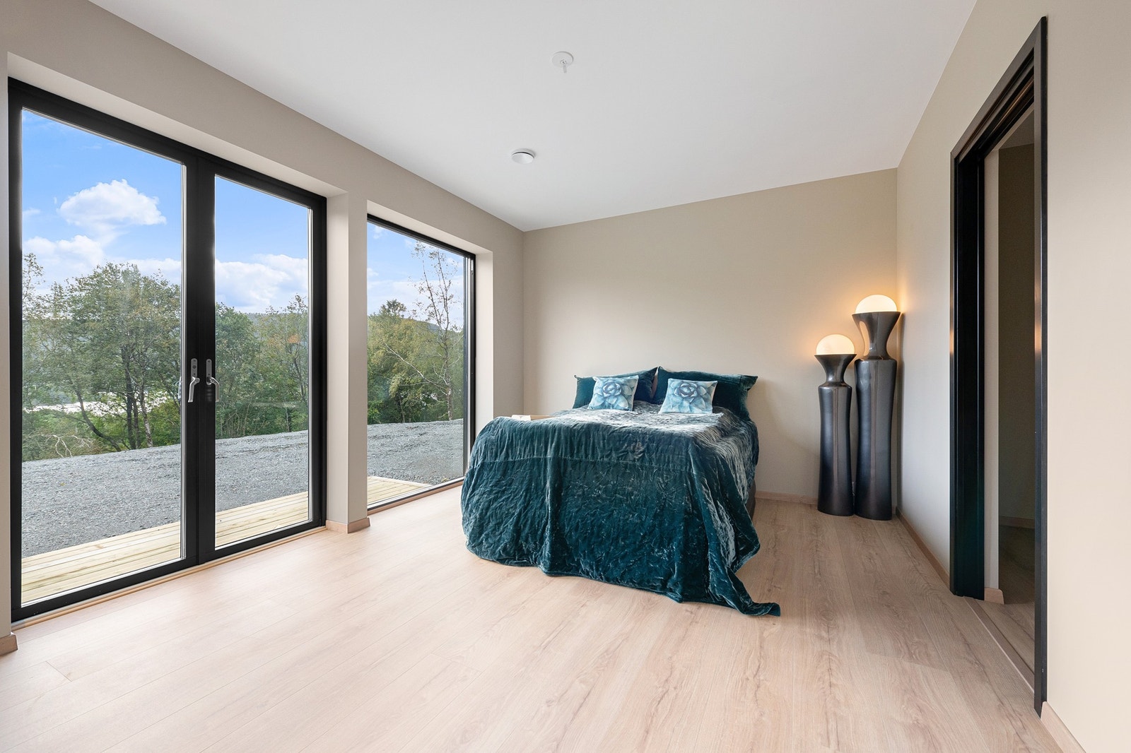 Romslig soverom med store vindusflater og utgang til terrasseplatting Galleribilde