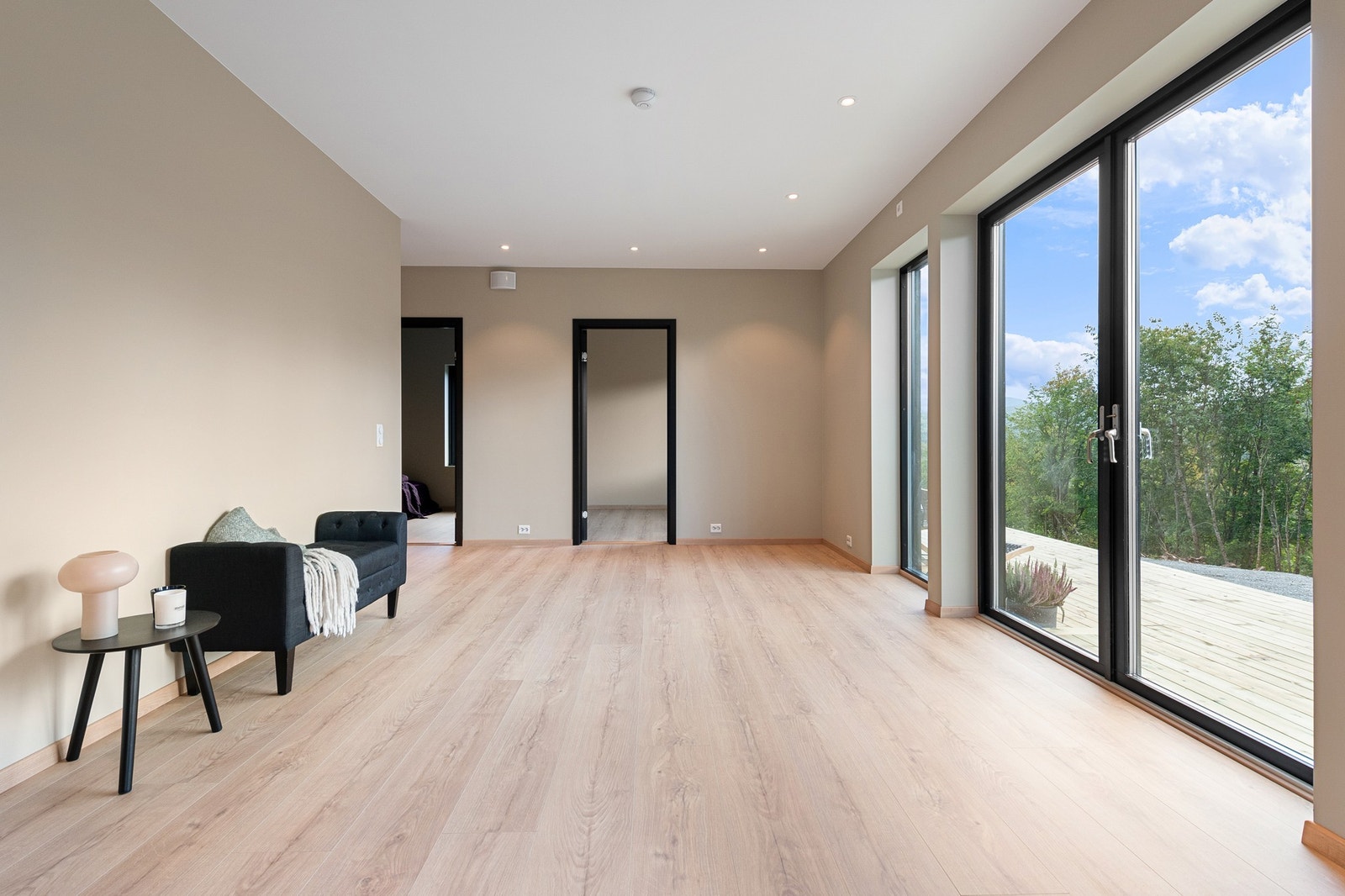 Lys og åpen stue i 1. etasje med direkte utgang til terrasseplattingen utenfor Galleribilde