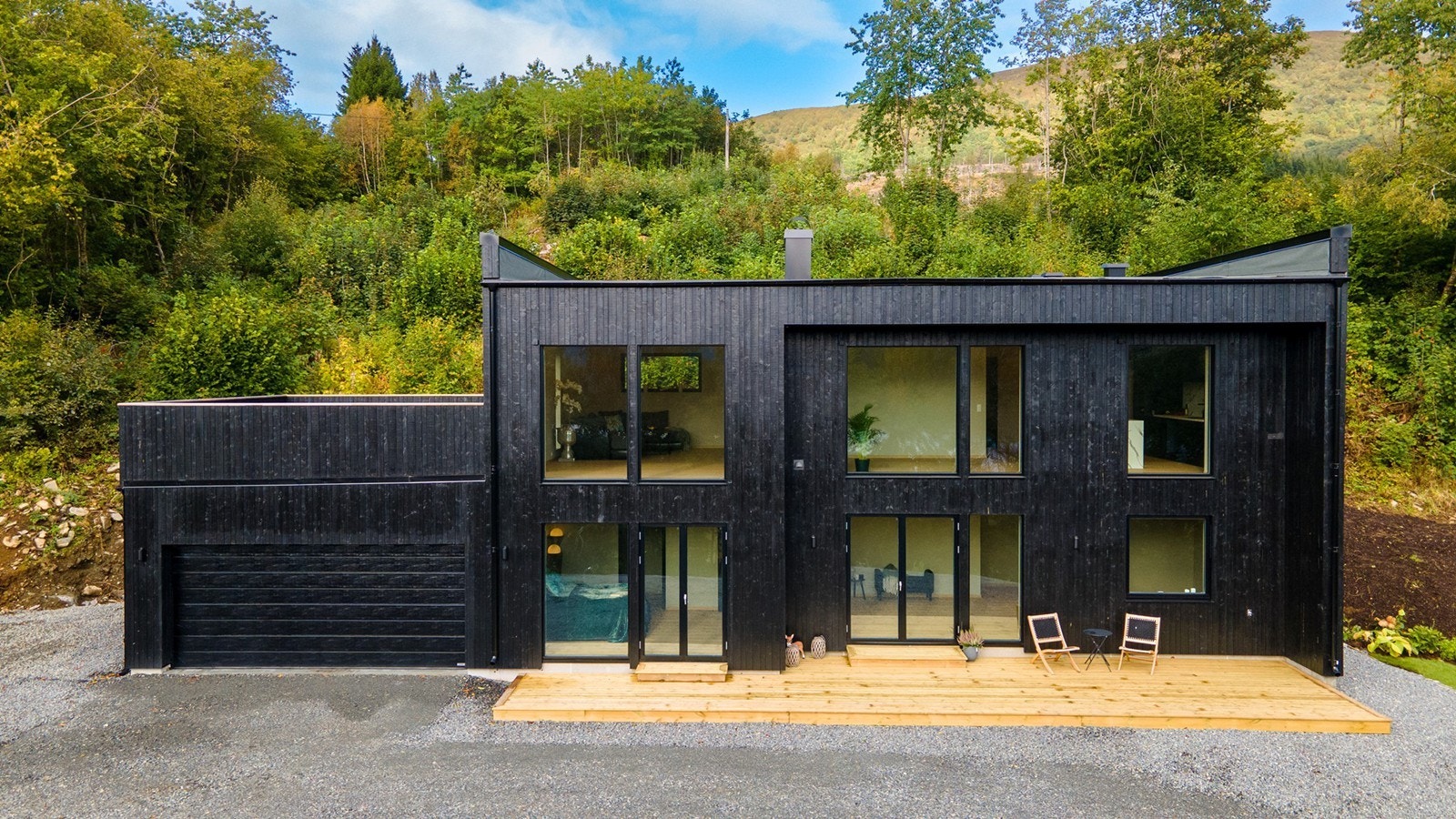 Tidsriktig arkitektur med mørk stående bordkledning, integrert garasje og flott uteareal Galleribilde