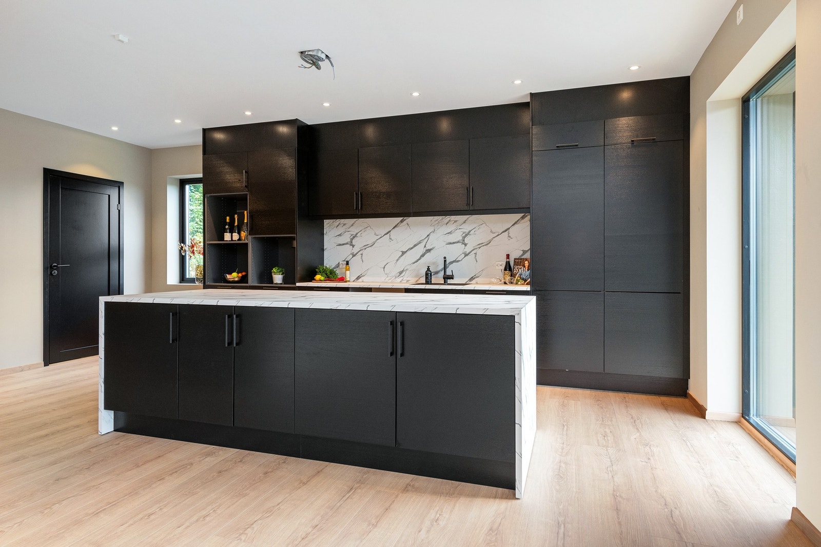 Kjøkkenet gir et moderne uttrykk med svært god skap- og benkplass Galleribilde