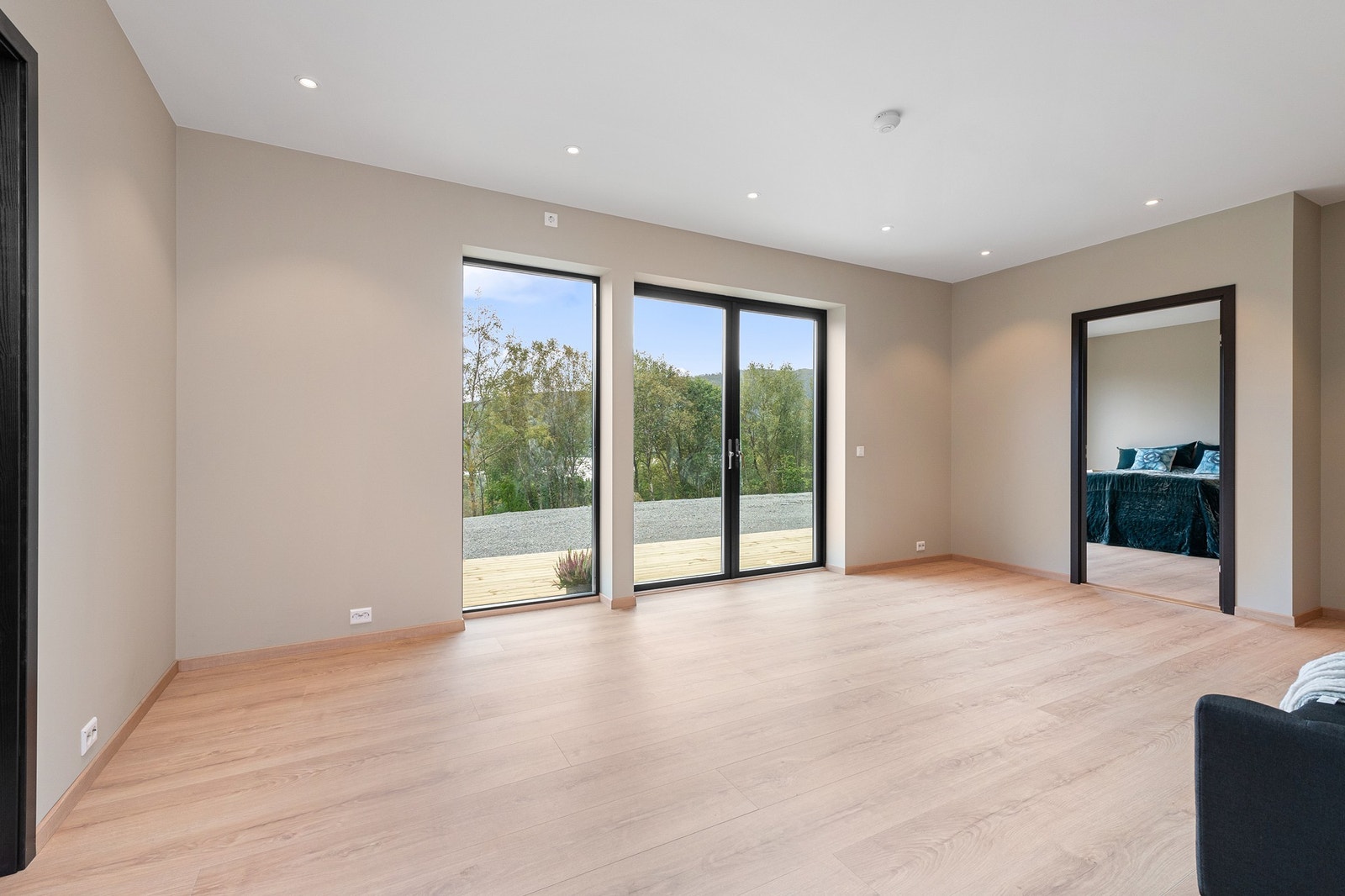 Lys og åpen stue i 1. etasje med direkte utgang til terrasseplattingen utenfor Galleribilde