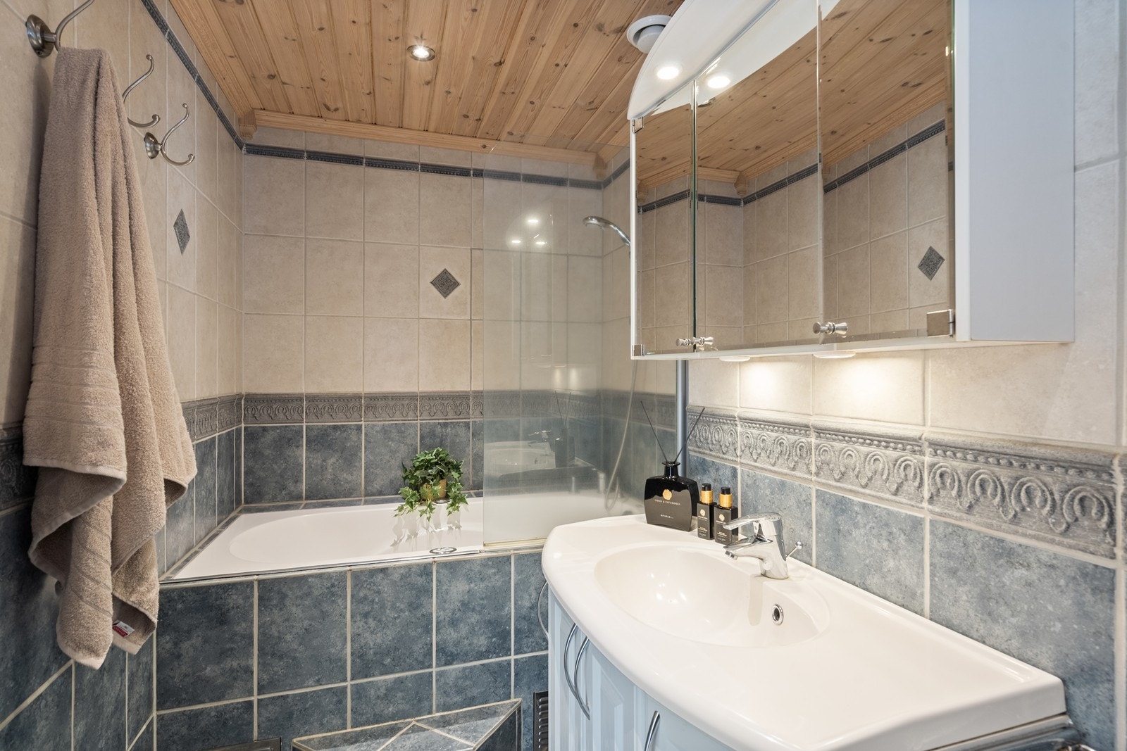 Rommet har innredning med nedfelt servant, veggfestet toalett og innebygget badekar med dusjmulighet. Galleribilde