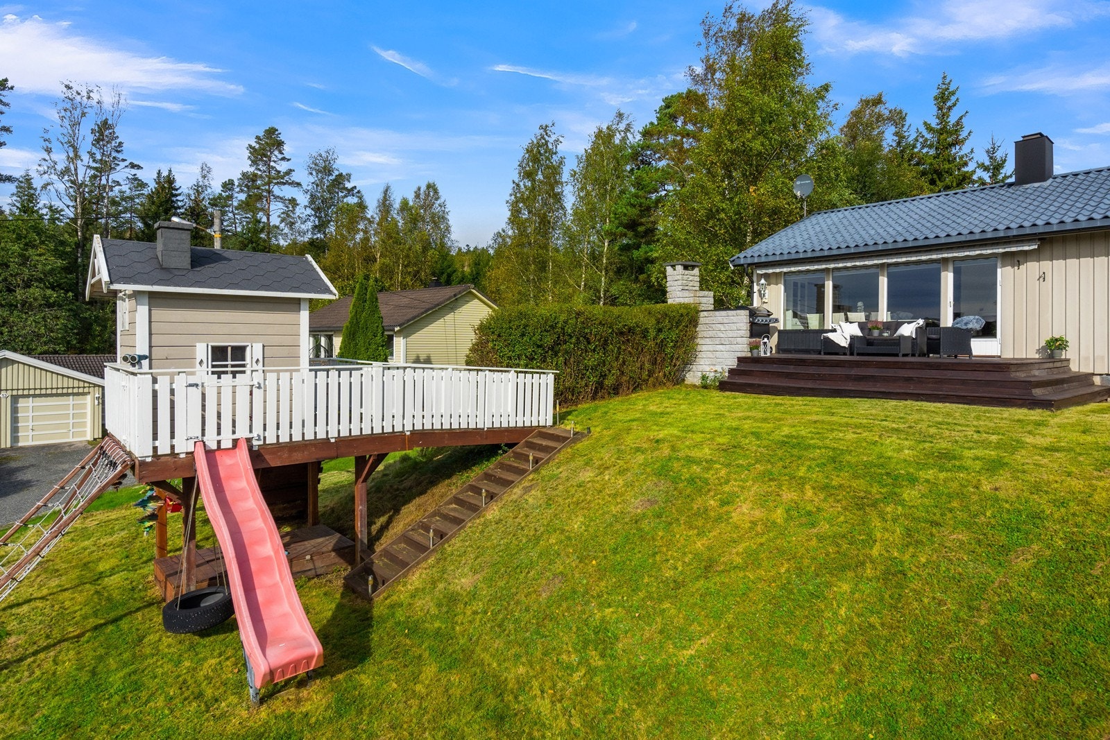 Her har barna sitt eget lekeområde med lekestue på platting, sklie og huske. Galleribilde