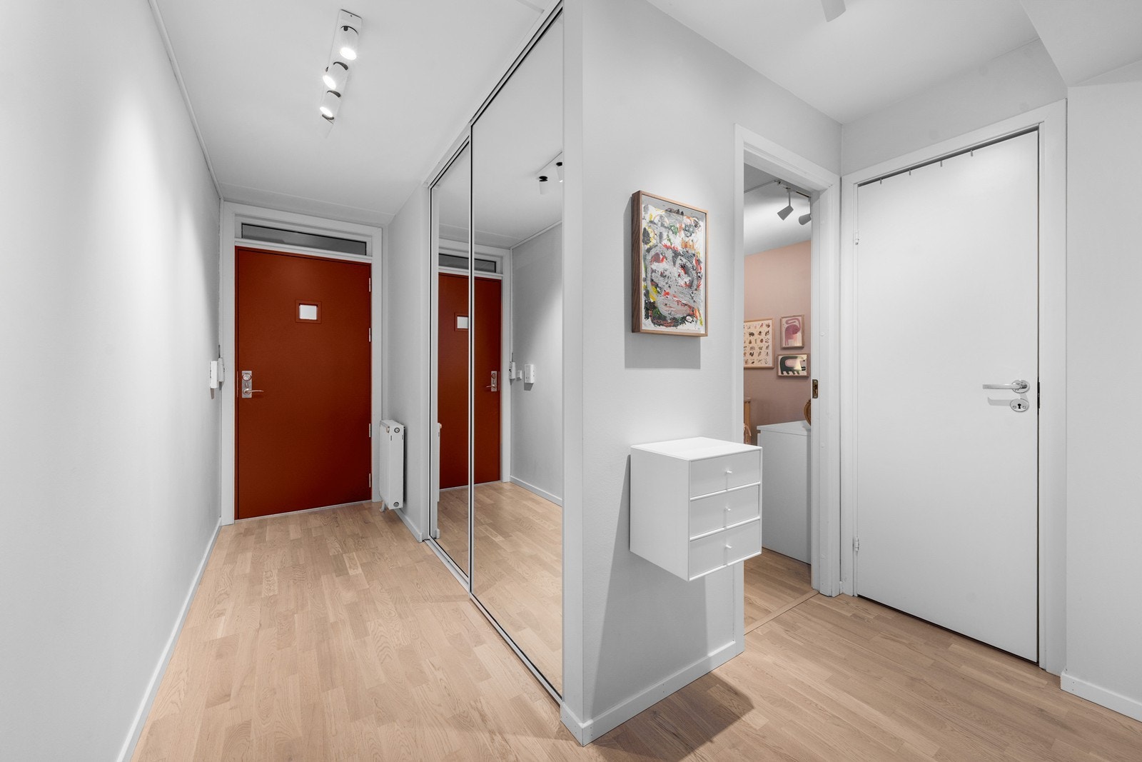 En lys og innbydende entré med en romslig skyvedørsgarderobe for oppbevaring. Galleribilde