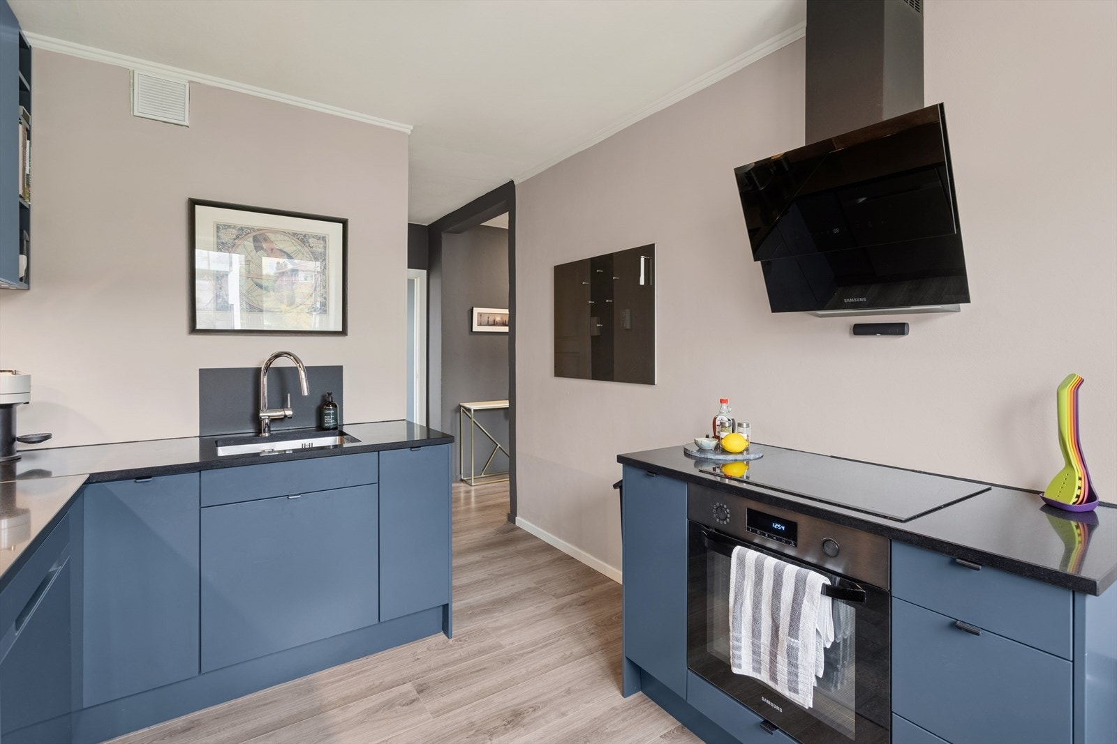 Benkeplaten i steinkompositt er utstyrt med kjøkkenkran og underlimt kum i rustfritt stål. Galleribilde