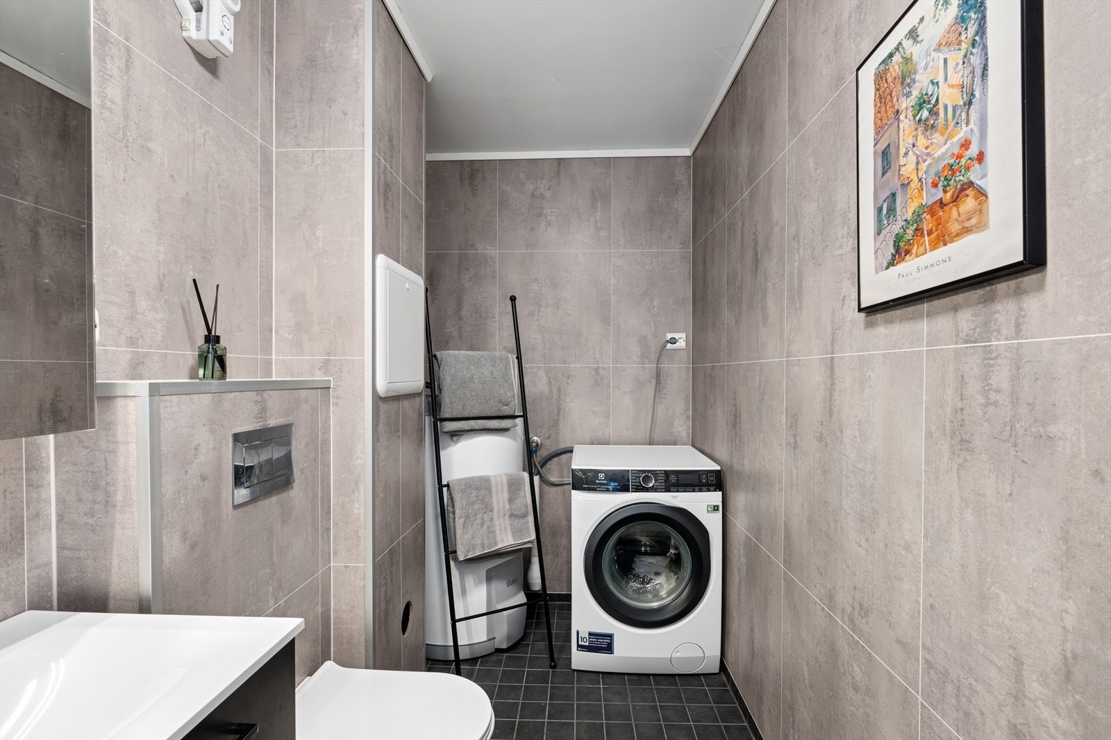 Badet har baderomsplater på veggene og fliser på gulvet med elektriske varmekabler. Galleribilde