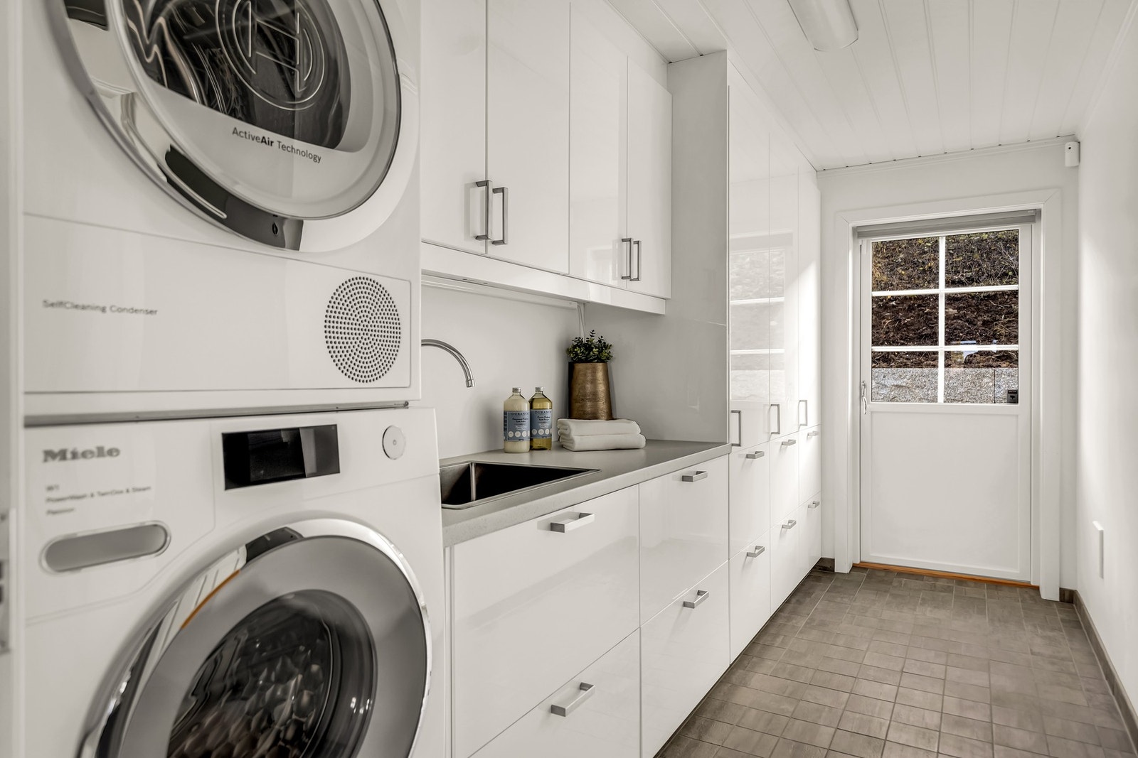 Et lyst, effektivt og velutstyrt vaskerom som kombinerer stil og funksjon. Med egen inngang ved garasjen. Galleribilde