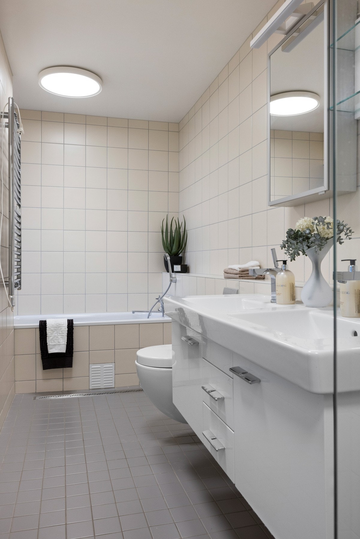 Rommet har vegghengt toalett, badekar samt dusjsone med nisjedører i herdet glass Galleribilde