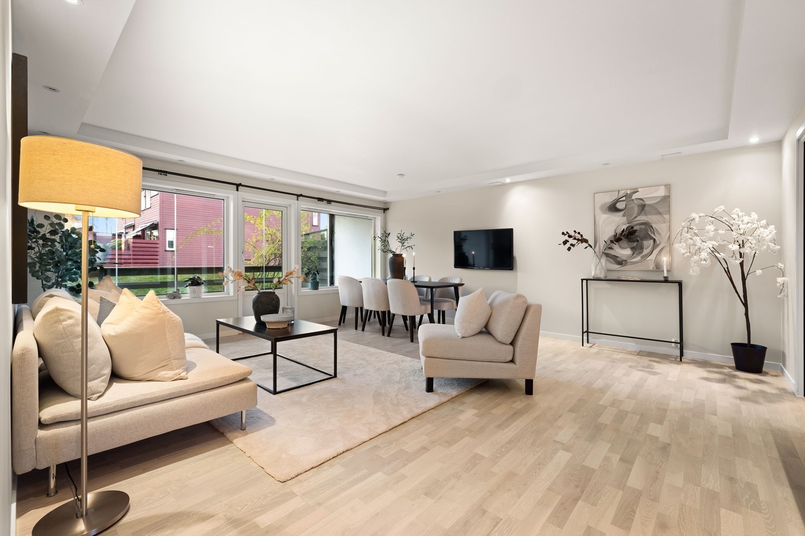 Stuen preges av store vindusflater som slipper inn rikelig med dagslys, og er malt i delikate, lyse fargetoner som skaper en moderne og innbydende atmosfære. Galleribilde