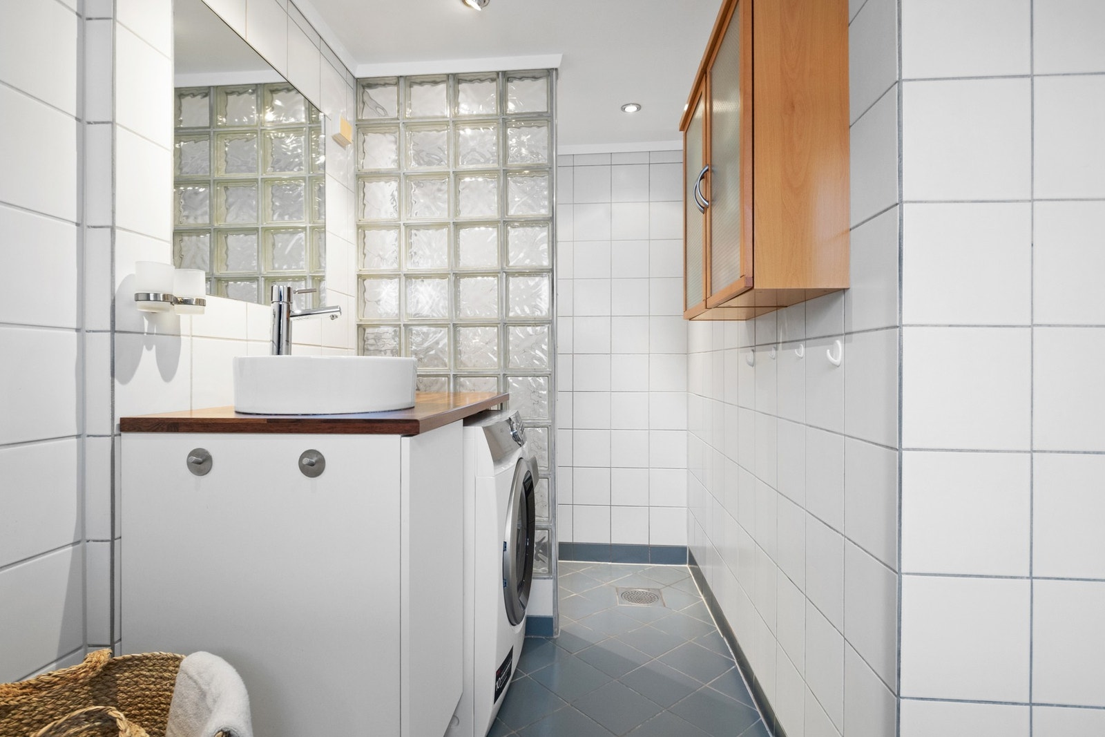 På badet er det både et innfliset badekar med dusjløsning og en nedsenket dusjnisje med vegg av glassbyggerstein. Galleribilde