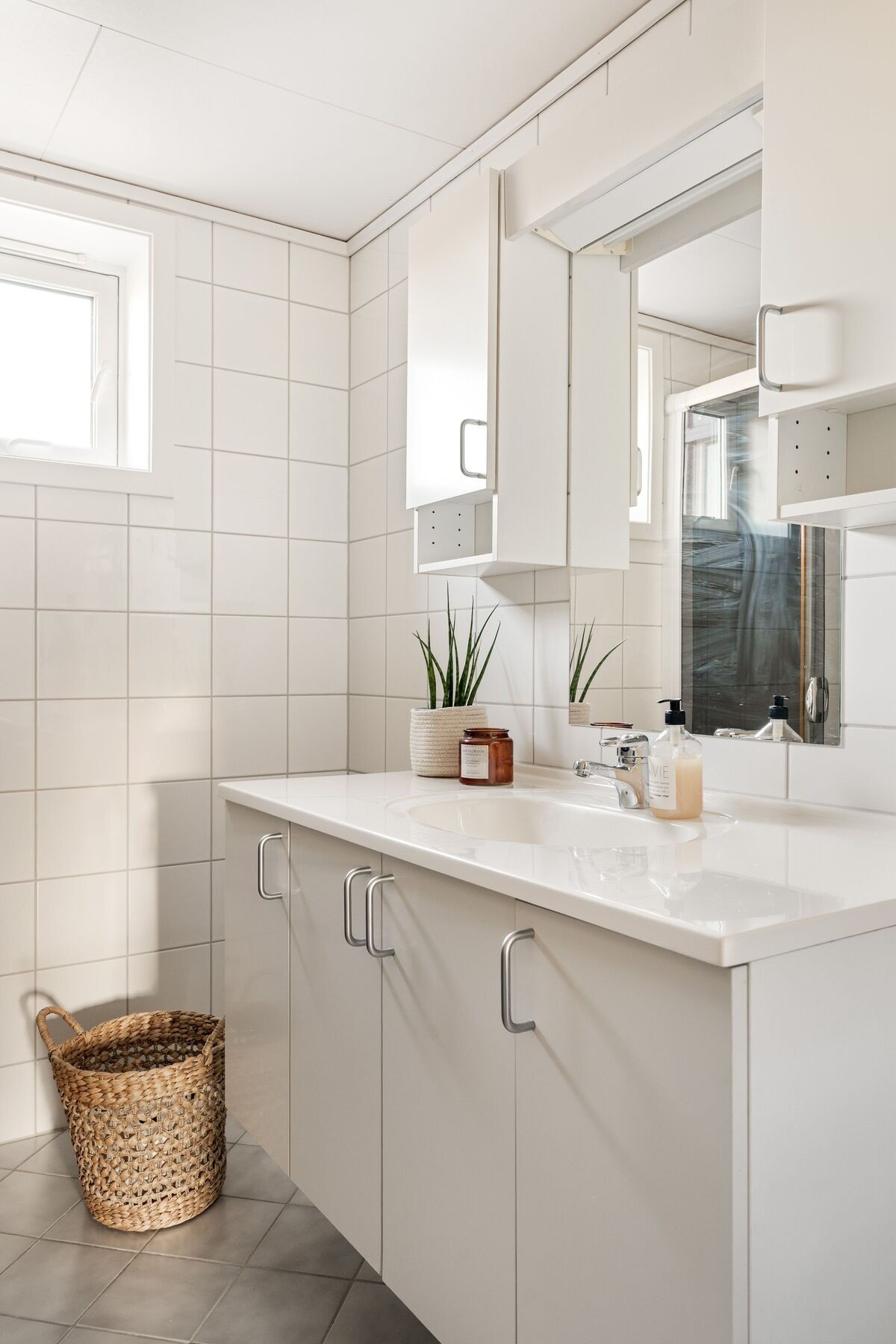 Badet er utstyrt med dusjhjørne, servant med over- og underskap, opplegg for vaskemaskin og vegghengt toalett. Galleribilde