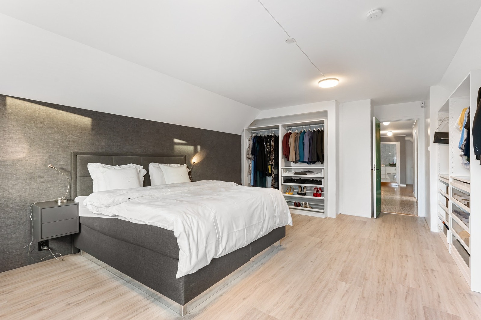 Hovedsoverommet er av svært generøs størrelse. En av garderobene strekker seg over hele langveggen, mens den andre dekker store deler av kortveggen - her får du både etterlengtet lagringsplass og god oversikt. Galleribilde