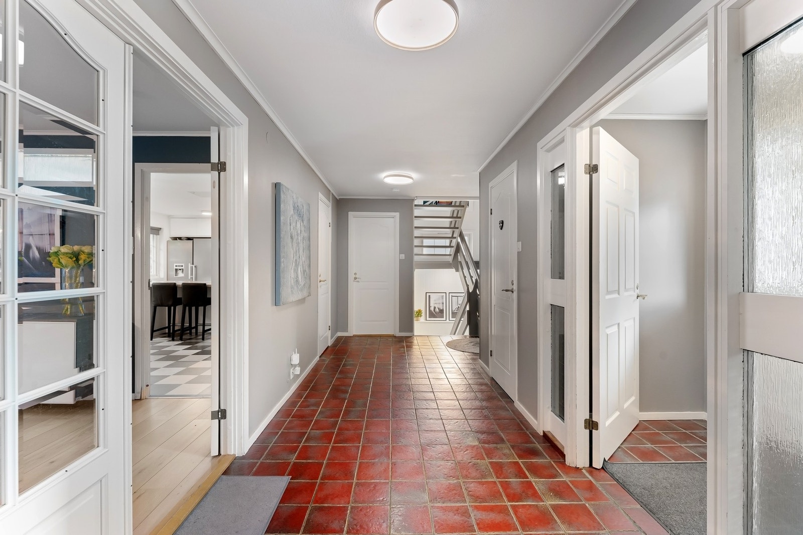 Skjermet fra de sosiale rommene, ligger mellomgangen/entreen med trappeløp til boligens 2. etg og u. etg. Bod rett forut, og WC-rom t.h. Galleribilde