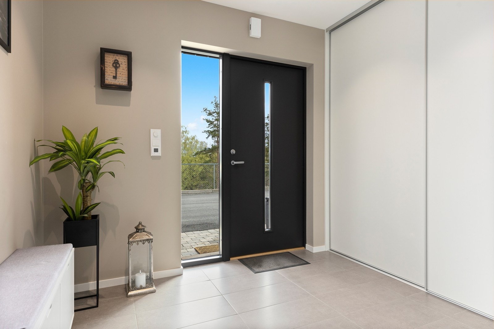 Innbydende og romslig gang som ønsker deg velkommen hjem. Gulvet har grå fliser som farmonerer godt med den lyse fargen på veggene. Galleribilde