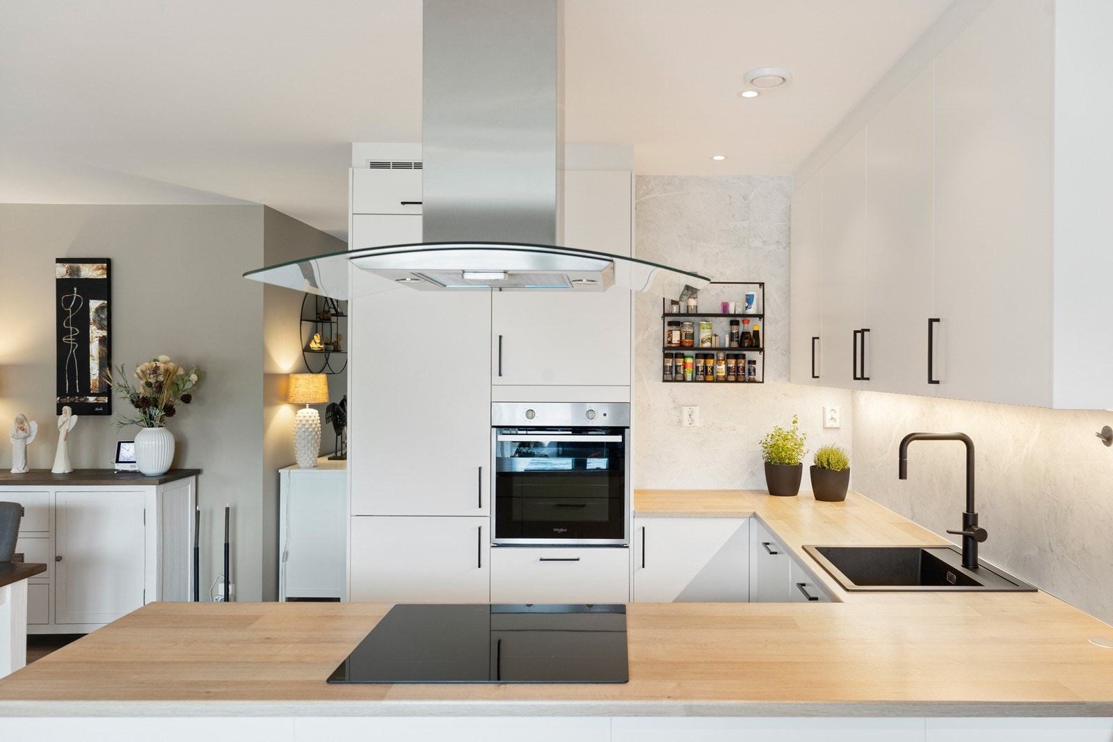 Kjøkkenet tilbyr funksjonalitet og har godt med skap -og benkeplass. Hvit slett innredning fra Mesterkjøkken med sorte håndtak. Integrerte hvitevarer. Over benkeplaten er det montert en marmorplate som tilfører et klassisk preg. Galleribilde