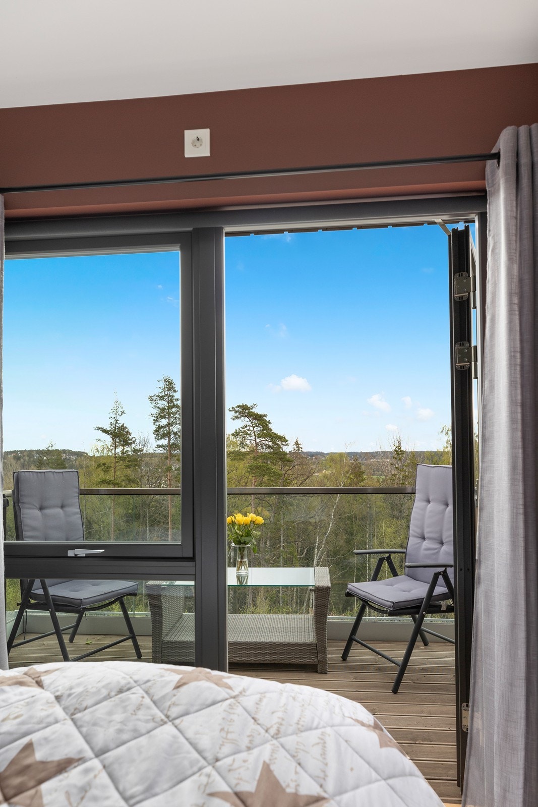 Hovedsoverommet har en dyp rødfarge på vegger og utgang til koselig veranda hvor morgenkaffen kan nytes. Galleribilde