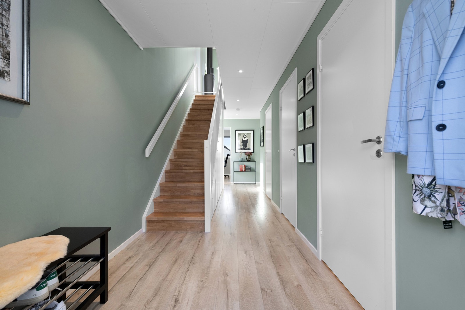 Romslig inngangsparti med spotter i tak og god lagringsplass under trapp Galleribilde