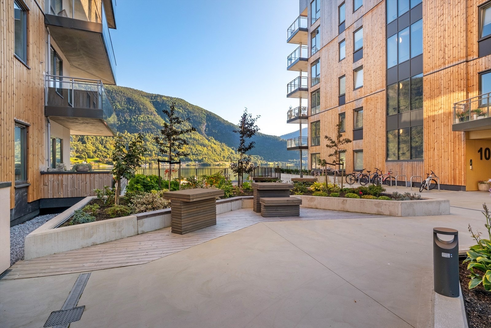 Fellesarealet er flott opparbeid med planter, tre, sittebenkar og bord. Galleribilde