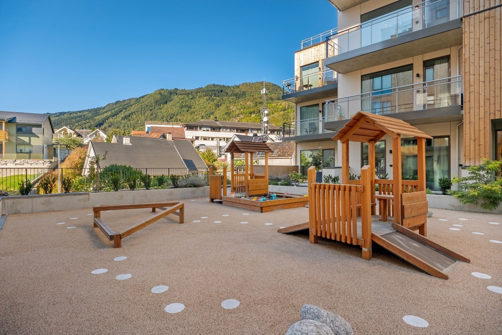 Triveleg felles leikeplass - eit trygt og sosialt samlingspunkt for dei minste med leikeapparat og god plass til leik og aktivitetar. Galleribilde