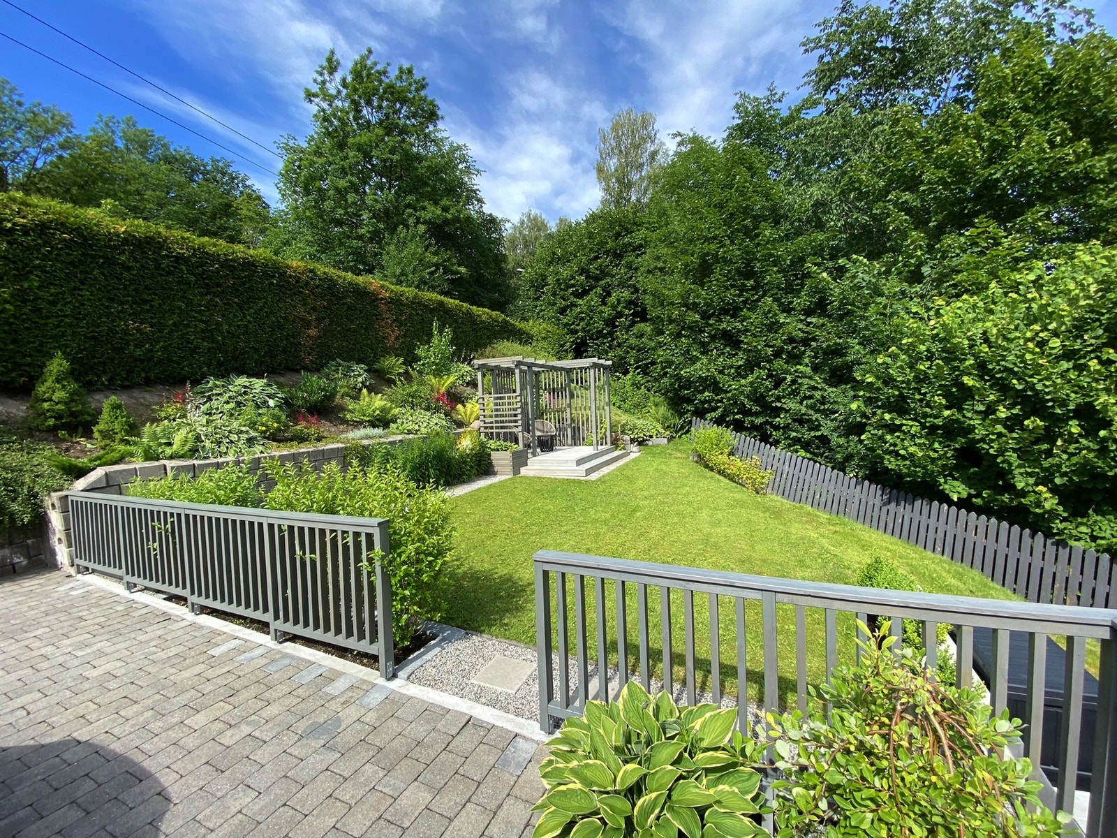 Flere lune soner med pergola, levegger og sittegrupper i ulike nivåer. Galleribilde