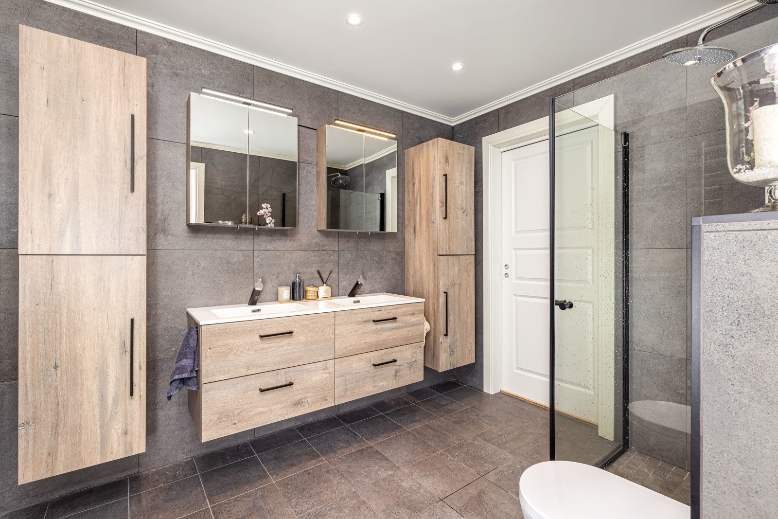 Badet er romslig & har godt med skapplass! Det er dobbelservant, vegghengt toalett og dusjhjørne. Galleribilde