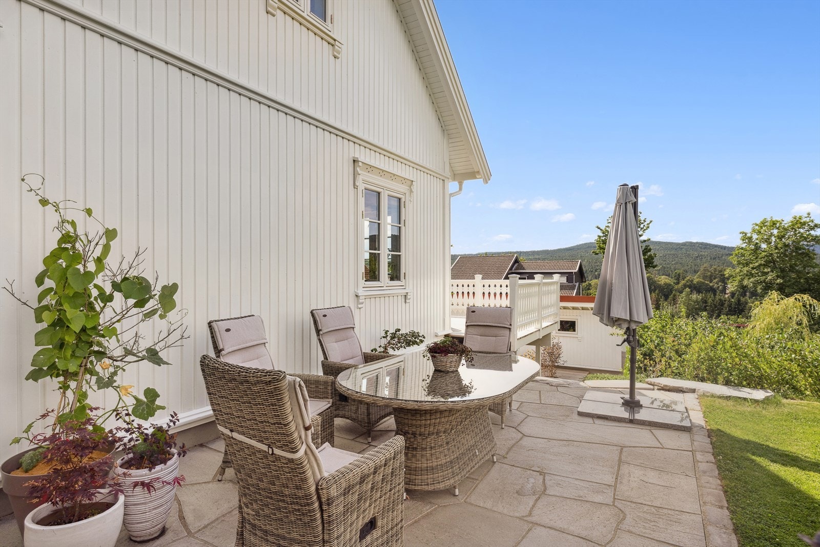 Skjermet uteplass på siden av huset med fint utsyn mot hagen. Galleribilde